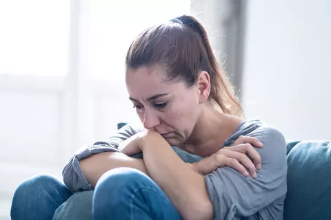 Nachdenkliche Frau mit verschränkten Armen